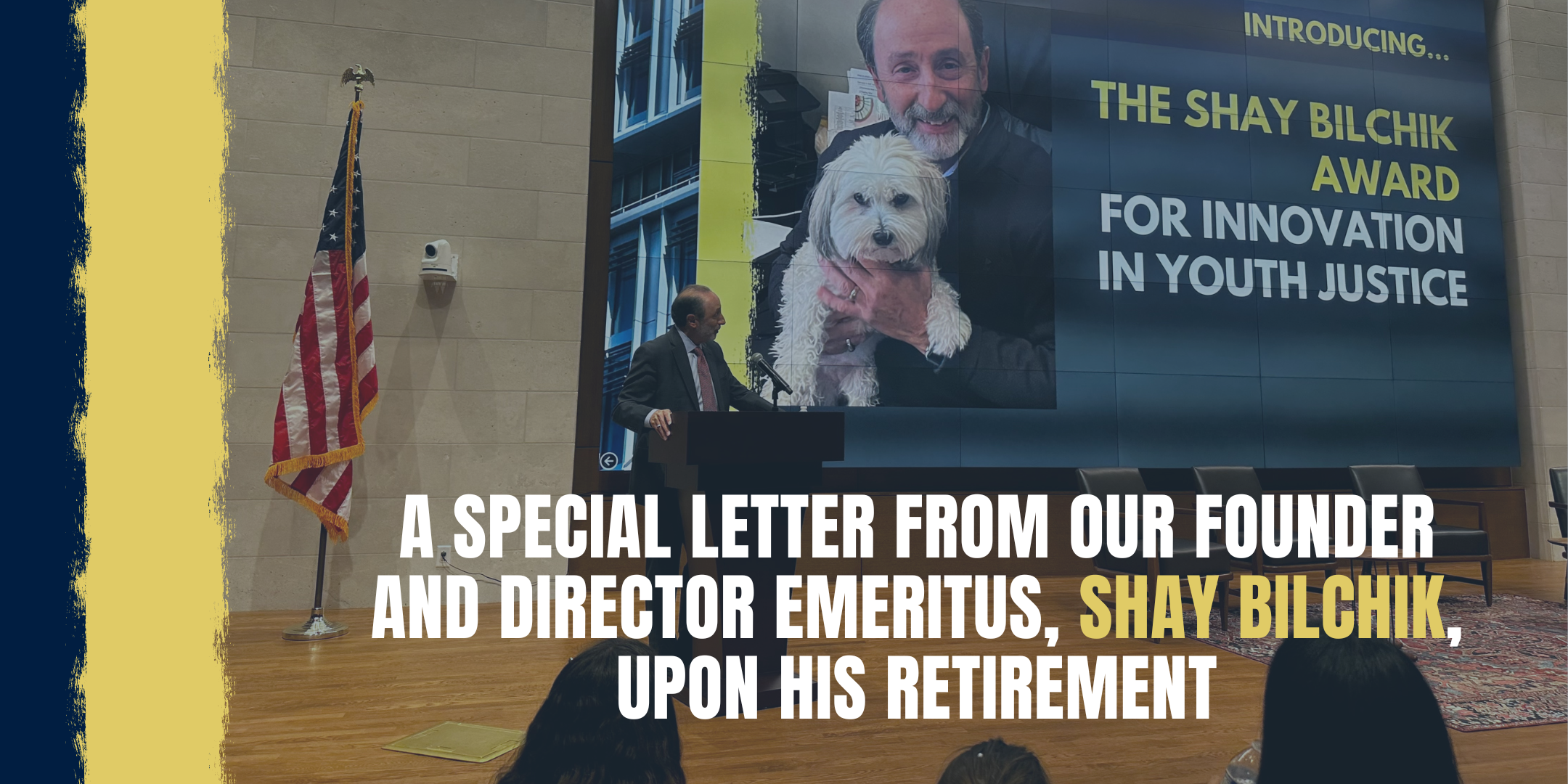 Shay Accepting Award on large stage, looking back at big screen announcing Innovation Award with him and his dog on it.