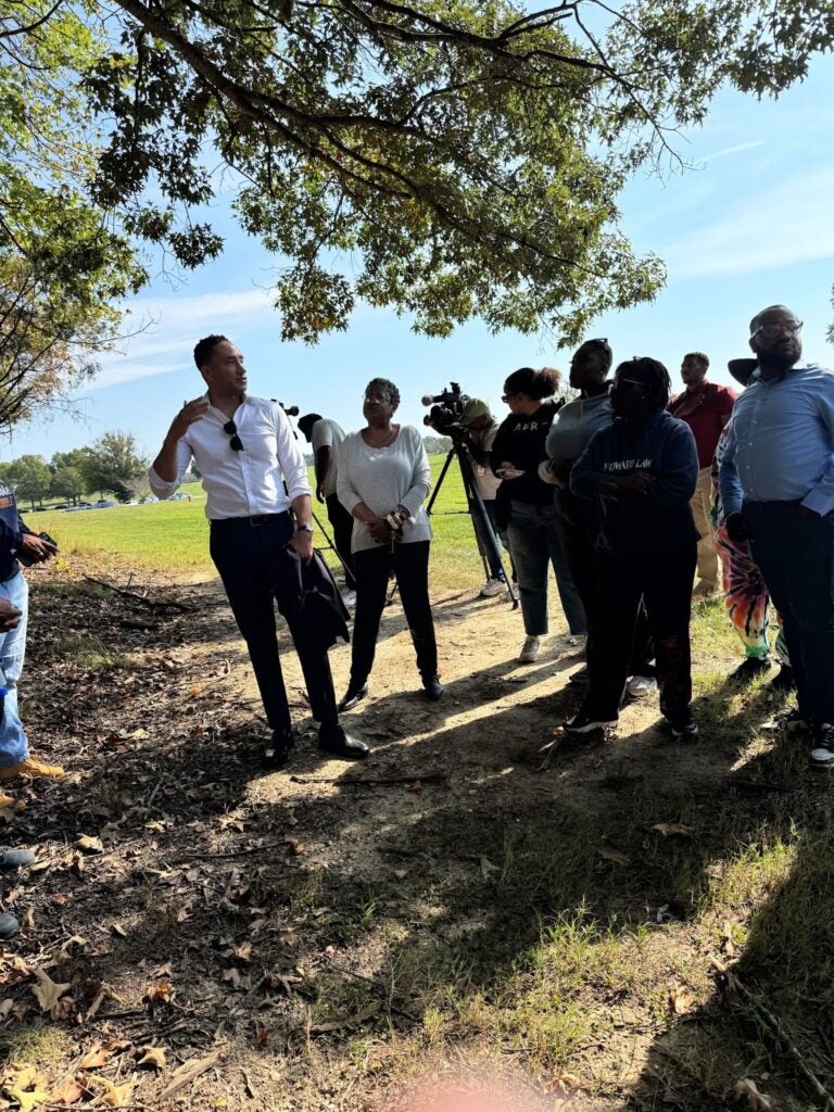 The Maryland Congressional Black Caucus stands at the edge of the field, looking at the burial site