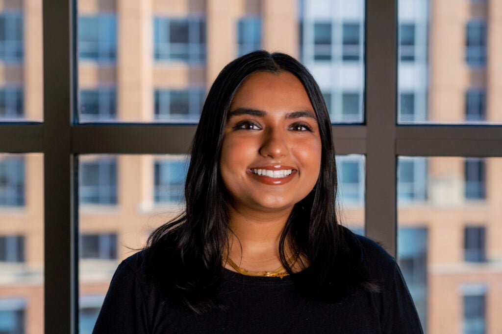 Anya smiling in front of window with DC buildings in background