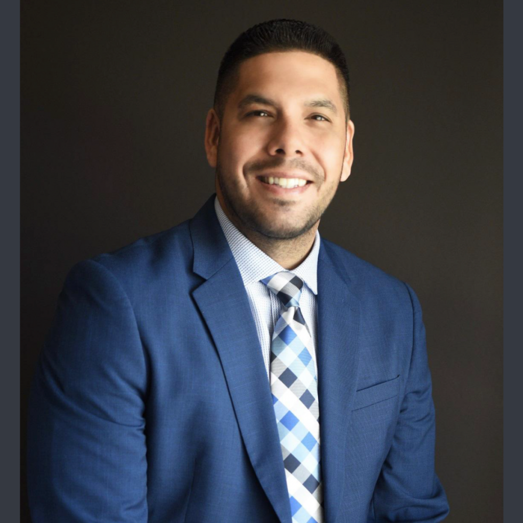 Ramon Ramos in suit smiling